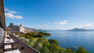 洞爺湖を一望できる北海道のラグジュアリーリゾートホテル。青空の下、湖と山並みを望む開放的なテラス席